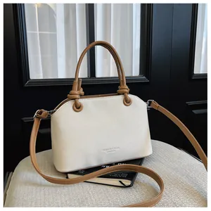 Vue détaillée d'un sac à main en toile blanche avec anses en cuir beige et nœuds