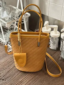 Stylish yellow woven bucket bag with top handles and adjustable shoulder strap for women