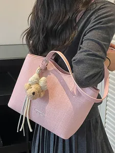 Elegant pink textured tote bag with cute plush bear charm for stylish commuter women