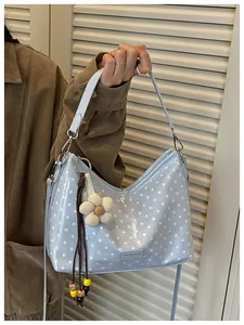 Stylish light blue polka dot hobo bag featuring a charming floral bag accessory