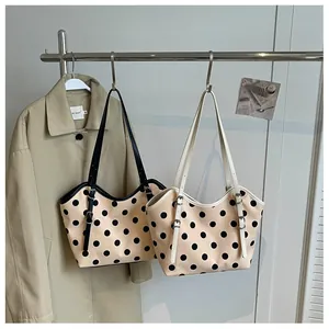Bolsos tote de lona con lunares vintage colgados en un estante con una gabardina.
