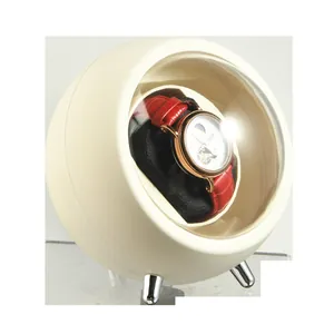 Close-up of a spherical automatic single watch winder in cream with clear glass window