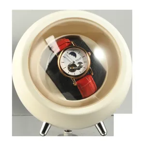Macro view of the cream spherical automatic watch winder for mechanical wristwatches