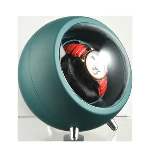 Close-up detail of a teal spherical automatic watch winder with a mechanical watch inside