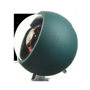 Side view of automatic watch winder featuring a spherical green casing and clear cover