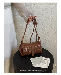 Primo piano di una mini borsa a tracolla intrecciata marrone minimalista stile retrò