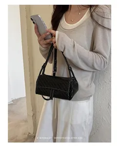 Dettaglio mini borsa quadrata nera intrecciata con cuciture bianche a contrasto