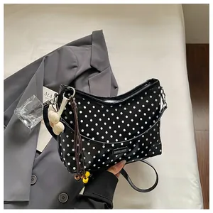 Chic black and white polka dot bucket bag with stylish tassel charm detail