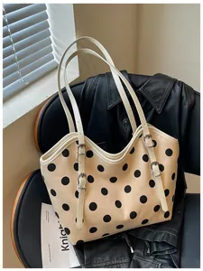Detalle de este bolso de lona retro con lunares y elegantes hebillas plateadas ajustables