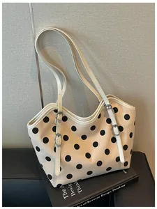 Detalle del bolso tote de lona retro con lunares y elegantes correas ajustables