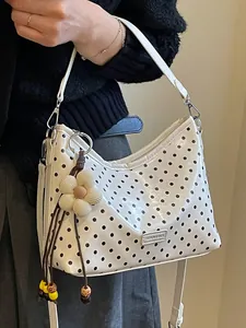 Stylish white hobo bag with black polka dots, flower charm and adjustable strap