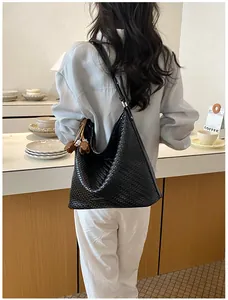 Stylish black woven hobo shoulder bag for women captured in a cozy lifestyle cafe setting