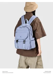 Vista posteriore di uno zaino in nylon blu minimalista e capiente indossato da un modello