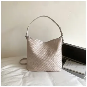 Close-up detail of beige woven large capacity tote bag for minimalist commuter style