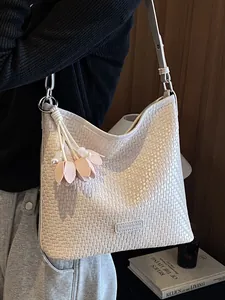 Large white woven tote bag for women featuring a minimalist floral charm pendant