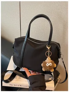 Vue détaillée d'un sac cabas en nylon noir avec un porte-clés monstre fantaisie