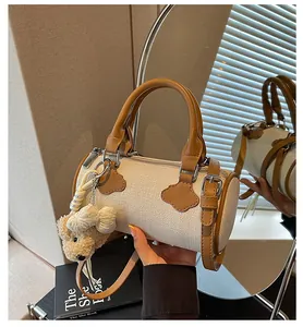 Elegant beige fabric cylinder handbag with brown leather trim and cute bear charm