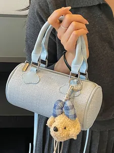 Light blue textured cylinder handbag for women with a cute plush teddy bear charm