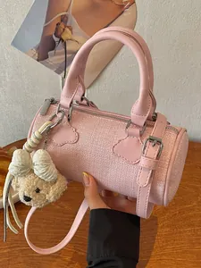 Elegant pink woven barrel handbag featuring a cute teddy bear charm for women
