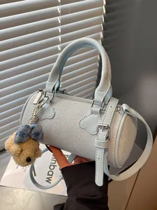 Stylish light blue woven barrel handbag for women featuring a cute plush bear charm