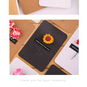 Detail of vintage kraft greeting cards decorated with small dried flowers and labels
