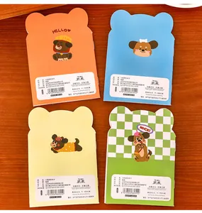 Detail view of 4 cute dog shaped mini notebooks showing cartoon covers and back labels