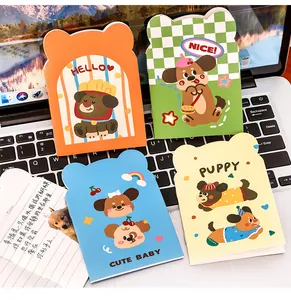 Close-up of four colorful cartoon puppy die-cut mini pocket notebooks on a laptop
