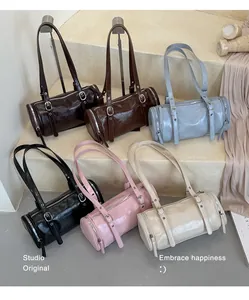 A group of vintage minimalist bolster bags displayed in various colors on studio steps