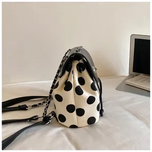 Seitenansicht eines stilvollen gepunkteten Kordelzug-Rucksacks mit Kette.