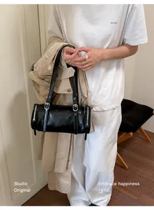 Detailed lifestyle shot of a vintage black minimalist shoulder bag with silver hardware accents