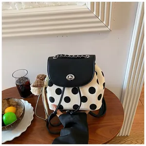 Detailansicht eines Rucksacks mit Polka-Dots und silbernem Metallverschluss.