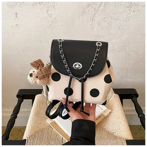 Nahaufnahme eines leichten gepunkteten Rucksacks mit niedlichem Bärenanhänger im Korea-Stil.