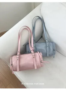 Stylish retro cylindrical pillow bags in pink and blue-grey shades on a minimalist sofa
