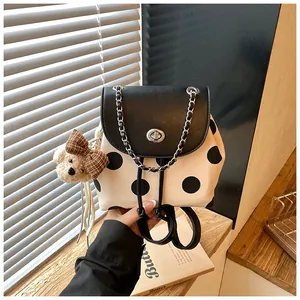 Detailansicht eines gepunkteten Mini-Rucksacks mit Plüschbär-Anhänger.