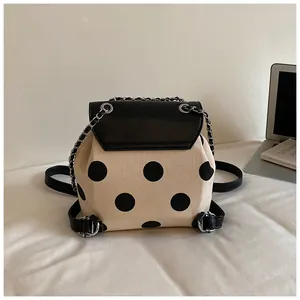 Detailansicht eines Rucksacks mit Polka-Dots in Creme und Schwarz und Kettenträgern im Lifestyle