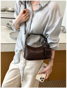 Close-up detail of dark brown woven hobo bag on a model in a natural lifestyle setting