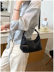 Stylish black woven hobo bag for women shown on shoulder in a lifestyle setting