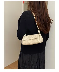 Dettaglio ravvicinato di una borsa a tracolla intrecciata crema con un outfit nero minimalista