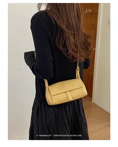 Borsa a tracolla intrecciata gialla su una modella per un look rétro minimalista