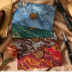 Vue détaillée d'enveloppes vintage texturées marbre avec sceaux de cire décoratifs.