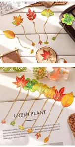 Close-up detail of creative metal leaf bookmarks with gold chains and matching charms