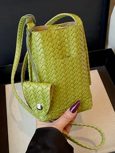 Élégant sac à bandoulière tissé vert vif pour femme avec une petite pochette assortie.