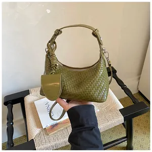 Detailed view of a green woven hobo bag featuring a matching detachable small pouch accessory
