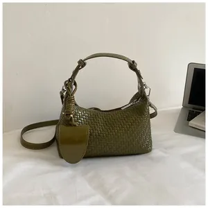Stylish olive green woven dumpling handbag shown in a minimalist modern lifestyle setting