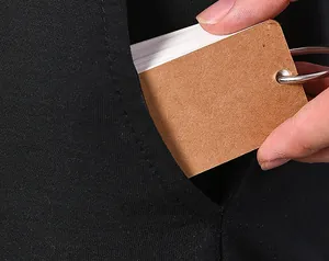 Detailed view of portable blank kraft loose-leaf memo book being tucked into a pocket