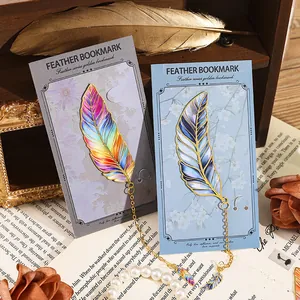 Creative colorful metal feather bookmarks with gold chain on vintage book backdrop