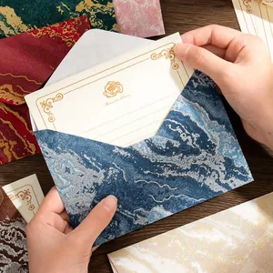 Elegantes sobres jaspeados con relieve en pan de oro y tarjetas de cartas a juego