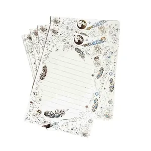 Carta da lettere stellata con dettagli in oro su uno sfondo bianco pulito.