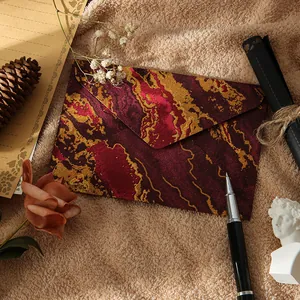 Enveloppe élégante en marbre bordeaux avec accents dorés pour les invitations.