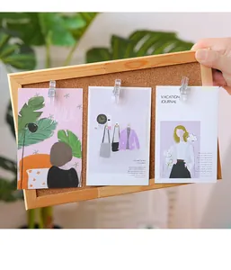 Detaillierte Ansicht transparenter Reißzwecken-Clips, die Postkarten an der Korkwand halten